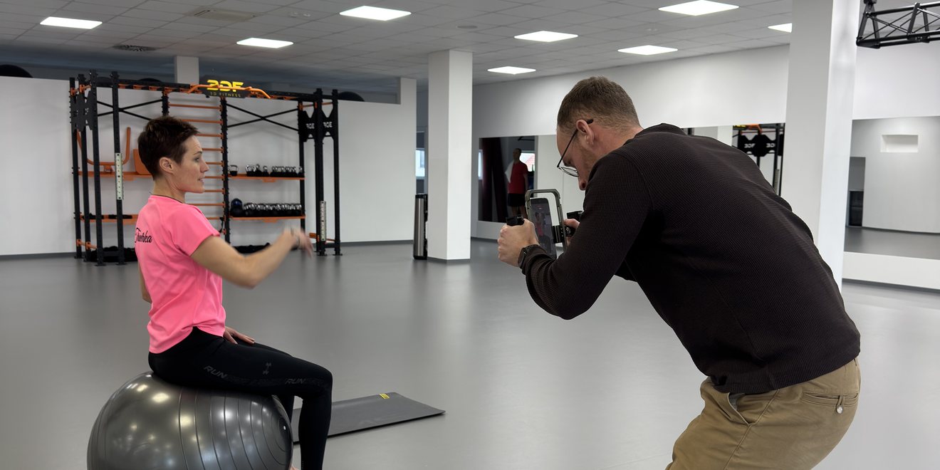 Lukáš natáčí trenérku ve fitcentru na telefon